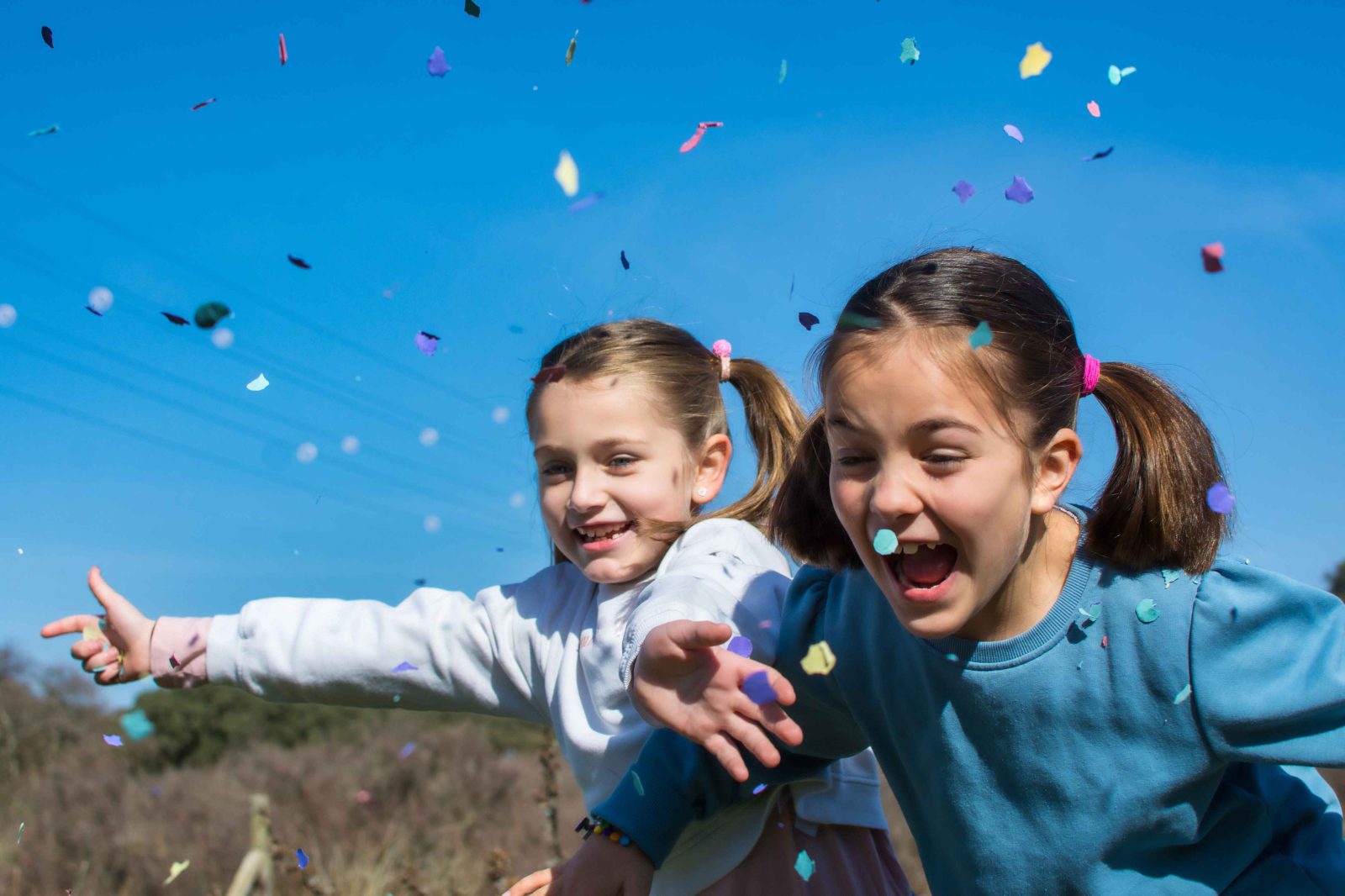 two excited girls celebrate with confetti outdoors 2026 01 11 10 44 52 utc 11zon